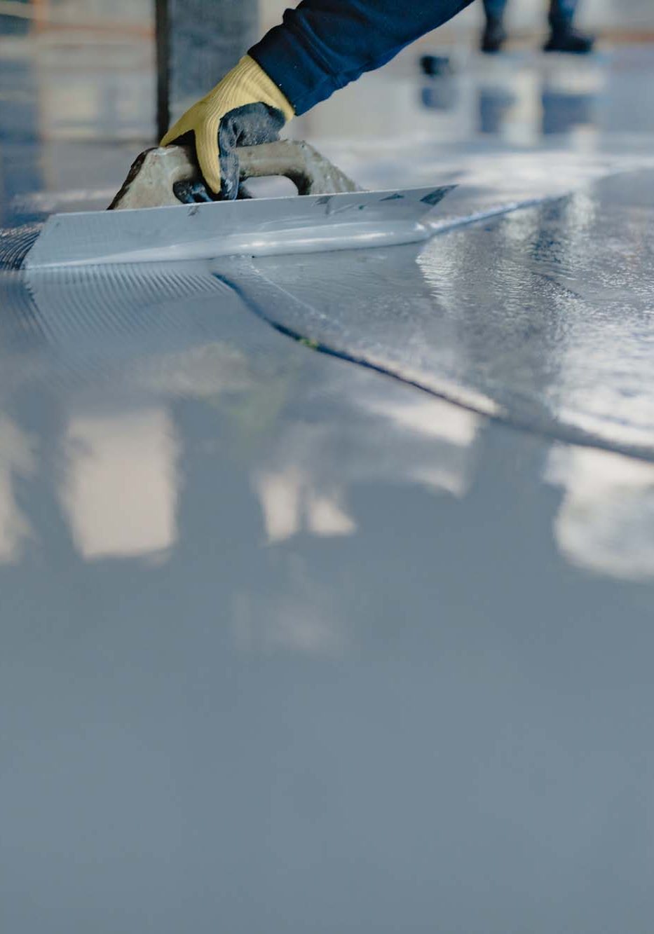 The worker applies gray epoxy resin to the new floor